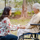 Holding touching hands Asian elderly woman patient in wheelchair at park with love. - PhotoDune Item for Sale