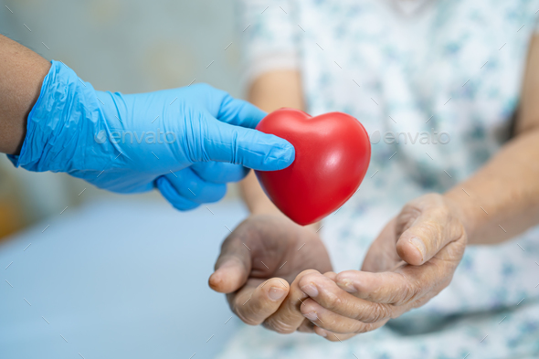 Doctor give red heart to Asian senior woman patient, healthy strong medical. - Stock Photo - Images