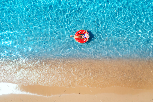Aerial view of a young woman swimming with red swim ring - Stock Photo - Images