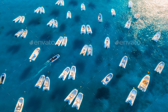 Aerial view of many motorboats on blue sea at sunset in summer - Stock Photo - Images