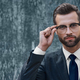 Young businessman looking into the distance holding one-handed glasses - PhotoDune Item for Sale