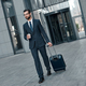 A young businessman spectacled crosses road with coffe and suitcase - PhotoDune Item for Sale