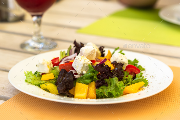 Greek salad on a white plate in a summer cafe - Stock Photo - Images