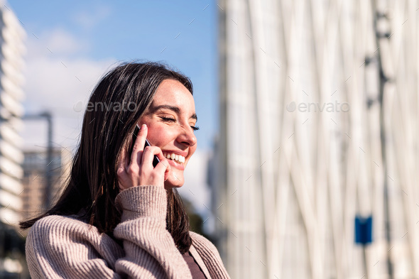 young woman smiling happy talking on mobile phone - Stock Photo - Images