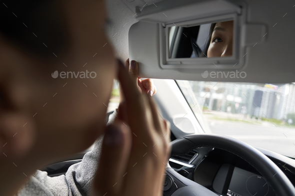 Close up of Chinese car driver looking at the mirror reflection - Stock Photo - Images