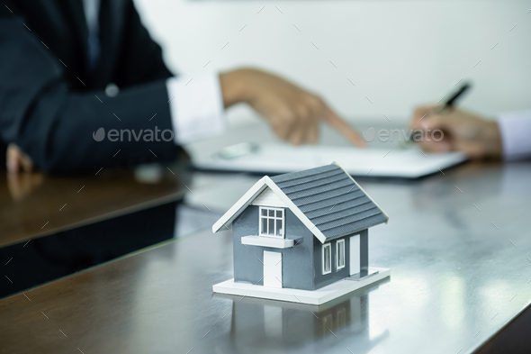 Home model standing in front of the property and interior agents are presenting houses