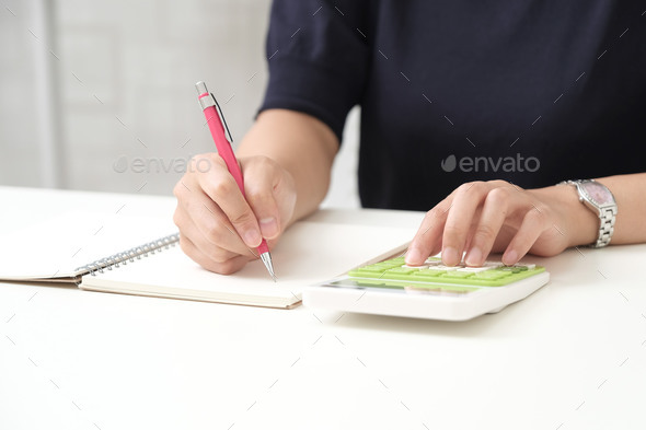Japanese woman calculating on a calculator - Stock Photo - Images