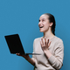 Surprised teen girl using laptop on blue studio background - PhotoDune Item for Sale