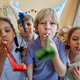Three children holding party blowers and having fun - PhotoDune Item for Sale
