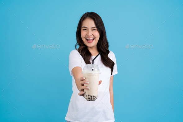 Asian girl holding a cup of pearl milk tea With a smile, fun and happiness