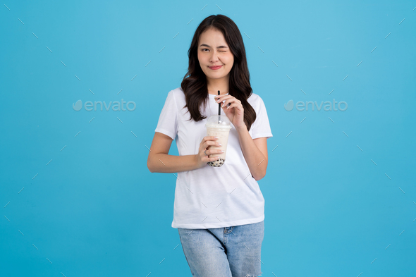 Asian girl holding a cup of pearl milk tea With a smile, fun and happiness