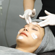 Young woman getting facial mask by professionals in beauty clinic. - PhotoDune Item for Sale