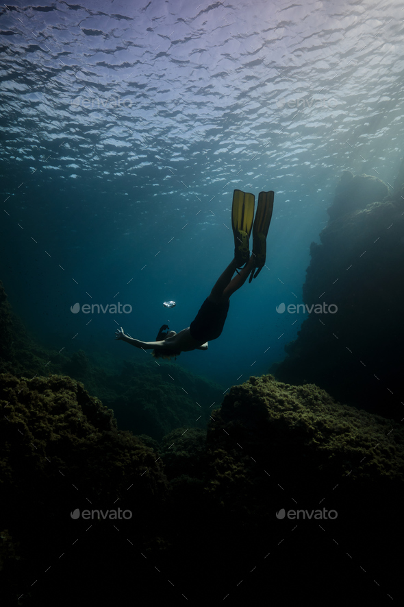 Man in flippers swimming undersea - Stock Photo - Images
