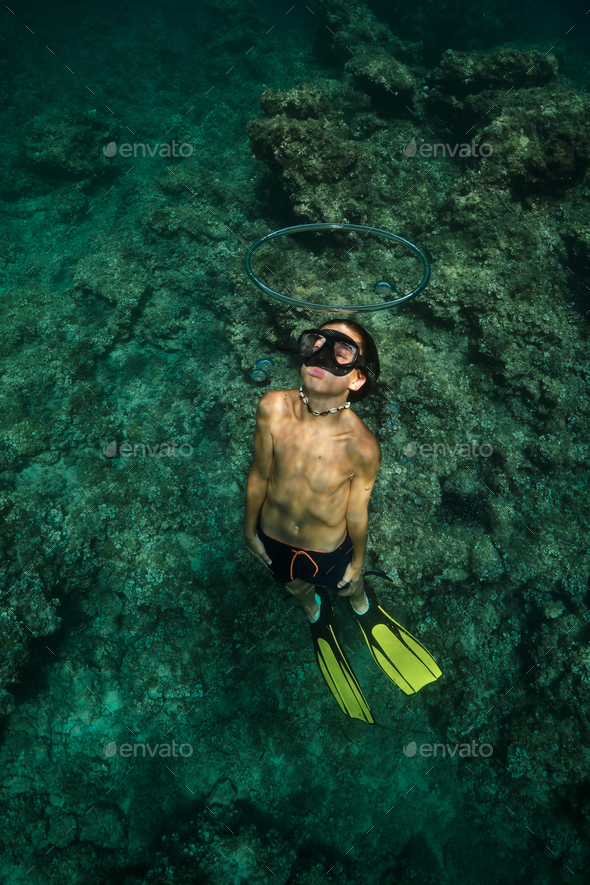 Shirtless boy swimming underwater in ocean - Stock Photo - Images