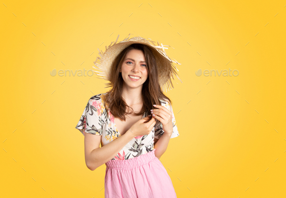 Satisfied caucasian smiling lady in summer outfit and straw hat enjoying holiday resort, posing on - Stock Photo - Images