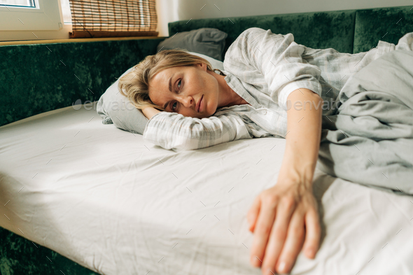 Beautiful blonde woman in pajamas on the bed in the morning after waking up. - Stock Photo - Images
