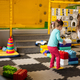 Two sisters playing at kids play center while build with colored plastic blocks. - PhotoDune Item for Sale