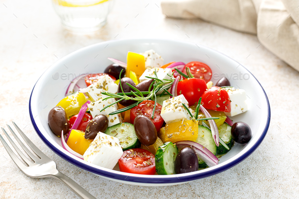 Greek salad. Vegetable salad with feta cheese, tomato, olives, cucumber, red onion and olive oil - Stock Photo - Images