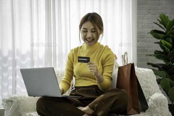 Easy and safe web shopping. Happy satisfied Asian lady buy goods use a credit card for secure paymen