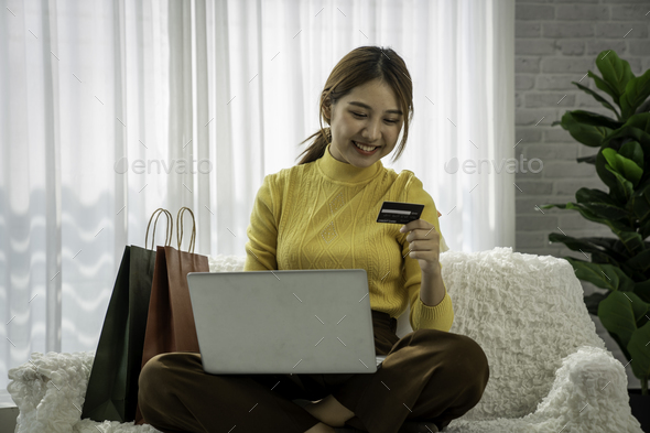 Easy and safe web shopping. Happy satisfied Asian lady buy goods use a credit card for secure paymen