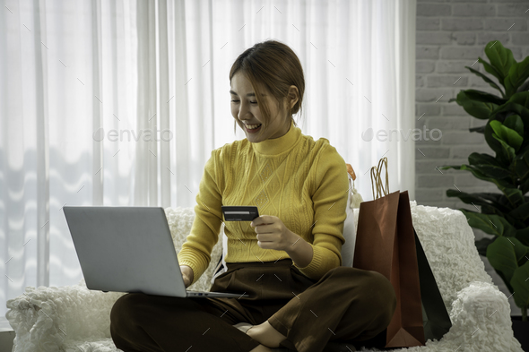 Easy and safe web shopping. Happy satisfied Asian lady buy goods use a credit card for secure paymen