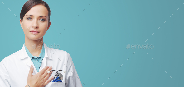 Female cardiologist touching with hand on chest - Stock Photo - Images