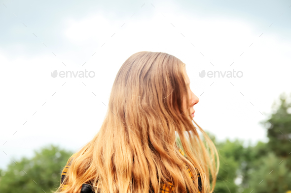 long curly blonde girl. Long hair. Back view. Rear view. Copy space. Freedom youth concept. Casual f