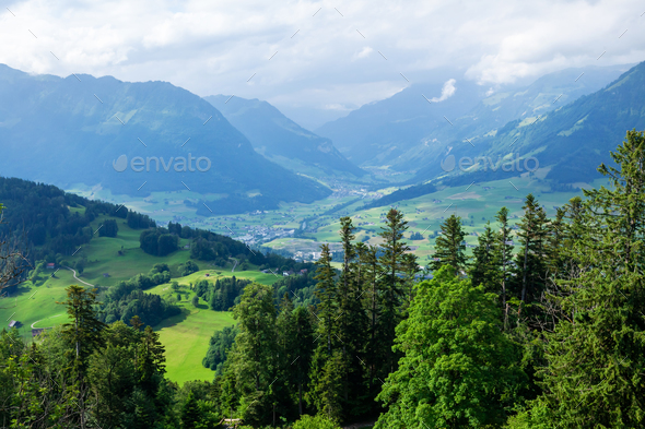 Panoramic view of countryside, green alpine meadows and mountains - Stock Photo - Images