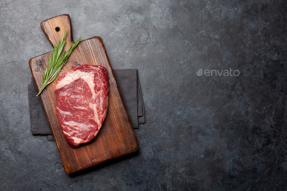 Raw ribeye steak on cutting board - Stock Photo - Images