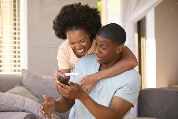Excited Couple In Bedroom At Home Celebrating Positive Pregnancy Test Result - Stock Photo - Images
