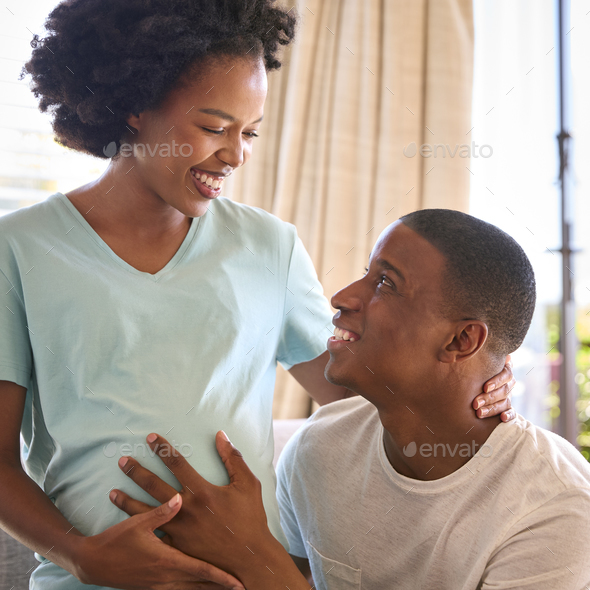 Couple With Pregnant Woman In Bedroom At Home With Man Feeling Baby Kicking - Stock Photo - Images