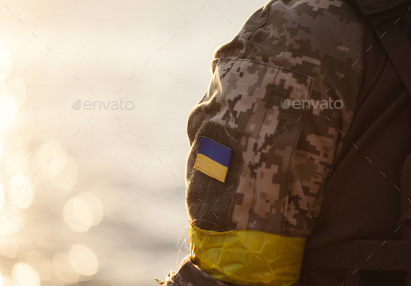the Ukrainian flag in the form of a chevron on the hand of a military man - Stock Photo - Images