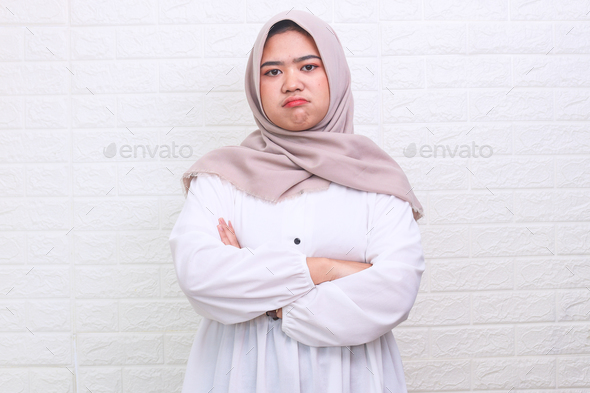 Moody Asian Muslim woman angry jealous with crossed arms  - Stock Photo - Images