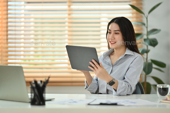 Smiling millennial woman reading email or checking daily routine on digital tablet,  - Stock Photo - Images