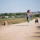 Beautiful young blonde woman running in the field with her greyhound dog. - PhotoDune Item for Sale