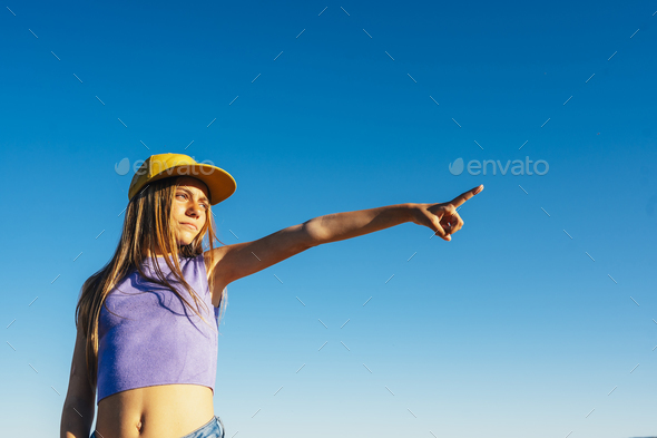 Outdoor portrait of a beautiful young blonde woman in a yellow cap and a bracket on her teeth. - Stock Photo - Images