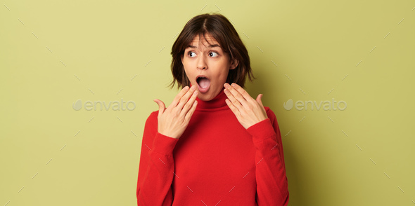 Amazed young ethnic lady with opened mouth looking away in studio - Stock Photo - Images