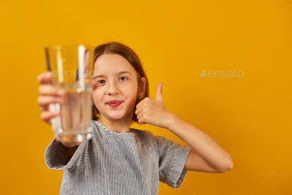 Pretty teen girl, child with a fresh glass of water isolated - Stock Photo - Images