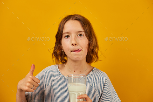 Pretty teen girl, child with a fresh glass of milk - Stock Photo - Images