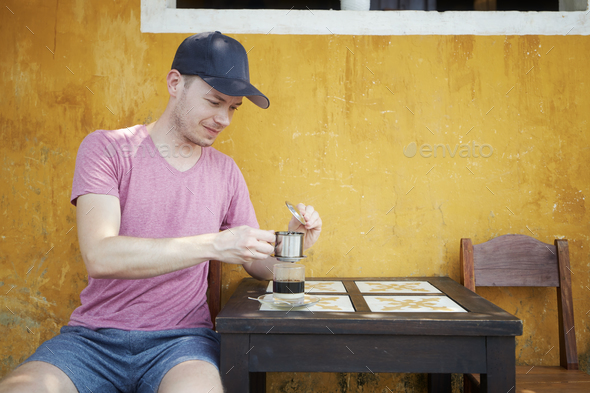 Man enjoying glass of traditional hot Vietnamese coffee - Stock Photo - Images