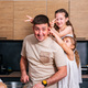 A young father cooks in the kitchen with his little daughters  - PhotoDune Item for Sale