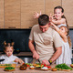 A young father cooks in the kitchen with his daughters and they give him horns and fool around. - PhotoDune Item for Sale