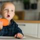 Little boy in a blue t-shirt sitting in a child&#39;s chair eating carrot copy space and empty space for - PhotoDune Item for Sale