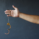 Hand of prisoner holding opened handcuffs. Free from jail or freedom concept - PhotoDune Item for Sale