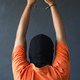Back view of prisoner in orange t-shirt raise his hands up while in handcuffs over grey wall - PhotoDune Item for Sale