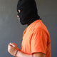 Side view of a prisoner in orange t-shirt wearing handcuff  - PhotoDune Item for Sale