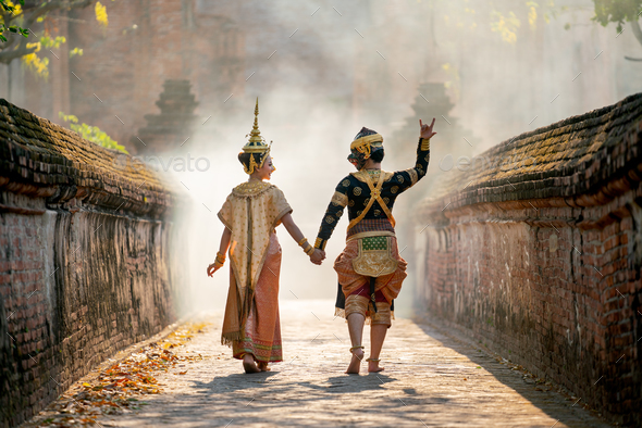 Asian woman wear Thai traditional dress action of walking with holdin hand with Thai classic masked