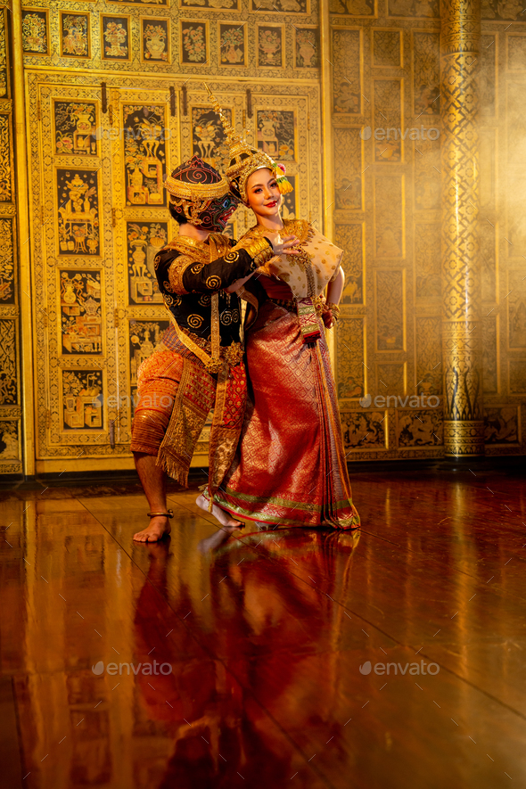 Wide shot of beautiful Asian woman wear Thai traditional dress action of dancing together with Thai