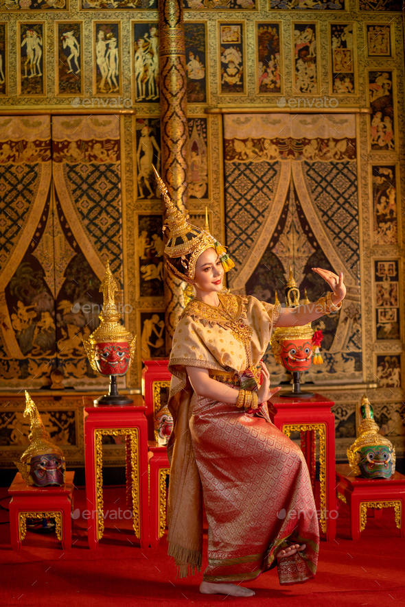 Beautiful Asian woman wear Thai ancient traditional dress action of dancing in front of shelves