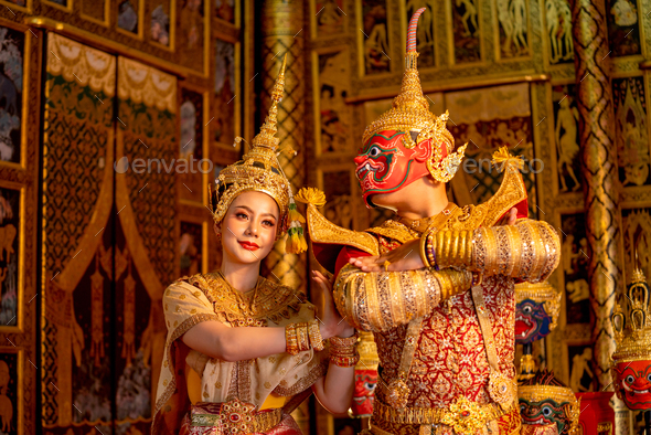 Beautiful Asian woman wear Thai traditional dress action of dancing together with Thai classic mask